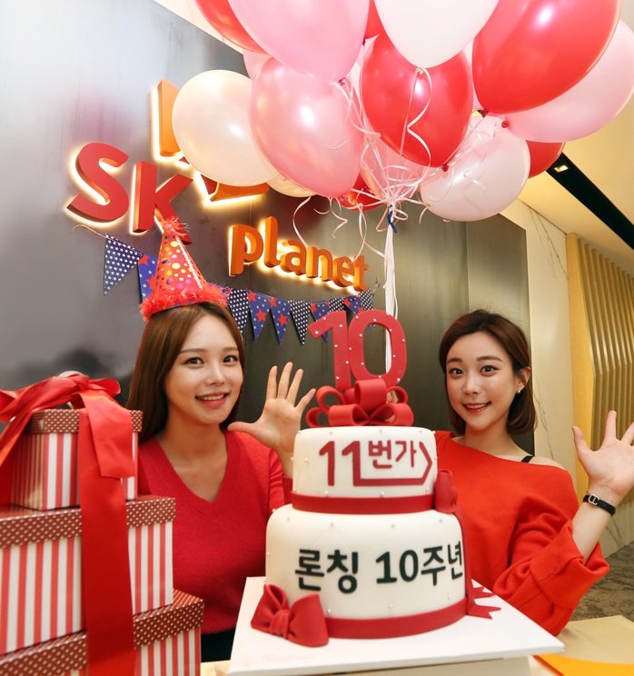 모델들이 3단 케이크 앞에서 11번가 론칭 10주년을 축하하고 있다.